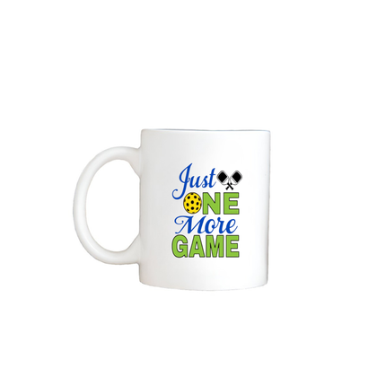 White mug with 'Just One More Game' text and tennis graphics on a white background