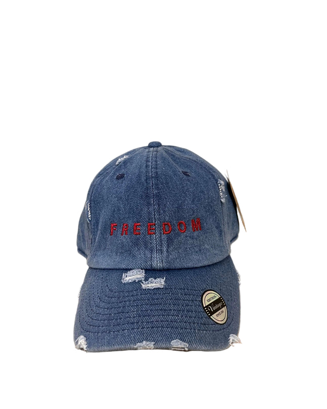 Blue distressed cap with 'FREEDOM' embroidery on a beige background