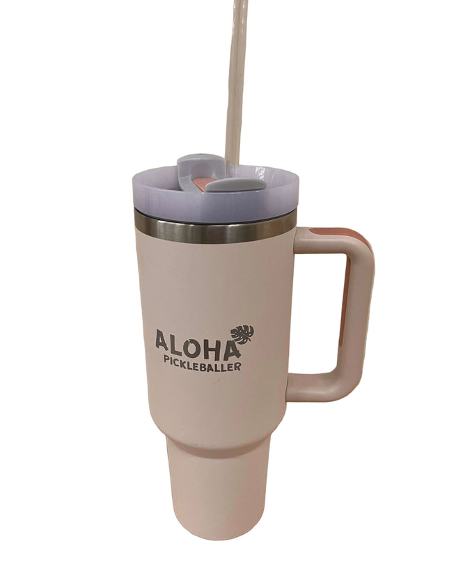 White travel mug with pink handle and blue lid on a wooden surface