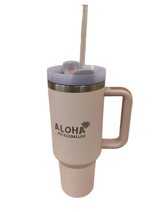 White travel mug with pink handle and blue lid on a wooden surface