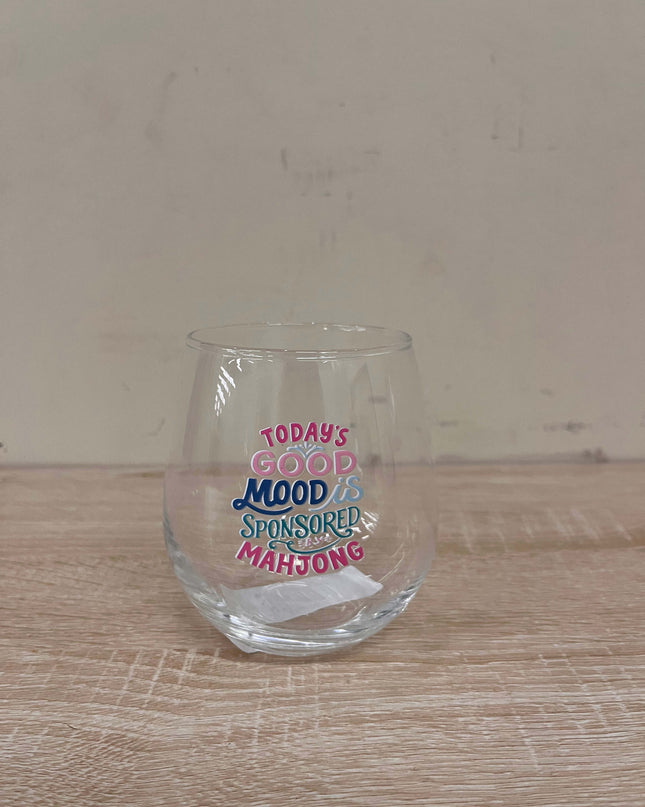 Clear glass with text on a wooden surface and beige background
